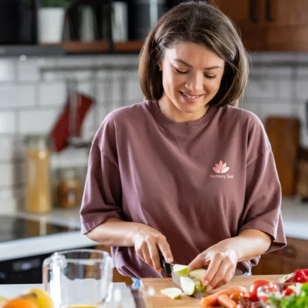 Person wearing a branded T-shirt is chopping vegetables