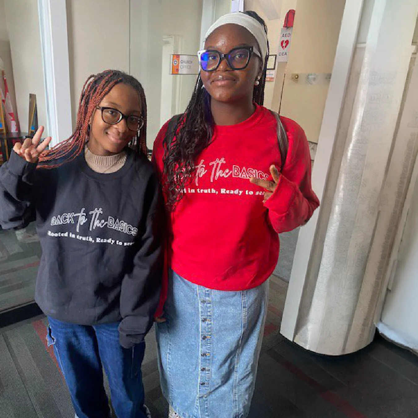 Two smiling youth wearing matching branded sweatshirts.
