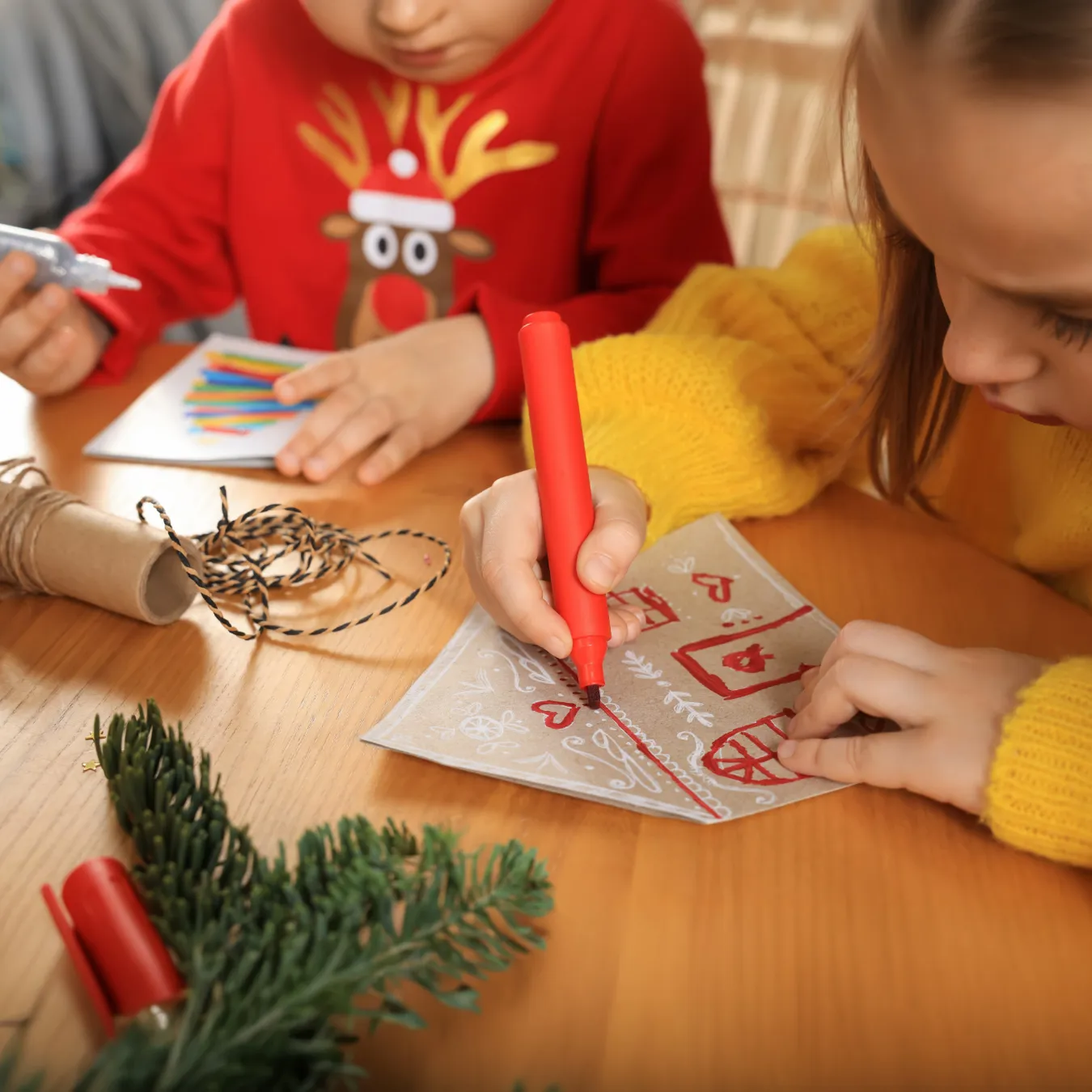 Two students doing holiday crafts at school.