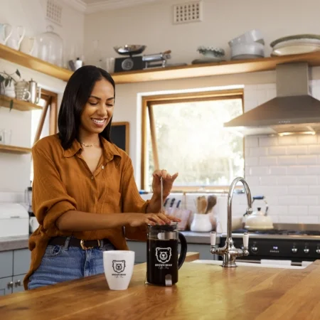 Person pouring coffee from a French press.