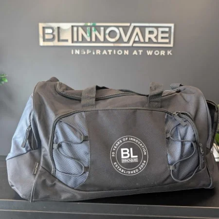 A grey duffel bag imprinted with a logo.