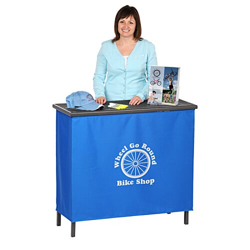 Additional Image 1 - a woman standing behind a blue counter