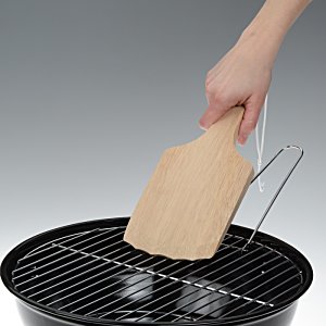 Additional Image 2 - a hand holding a wooden board over a grill