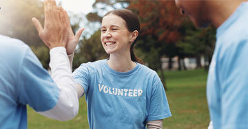 Volunteer workers high fiving