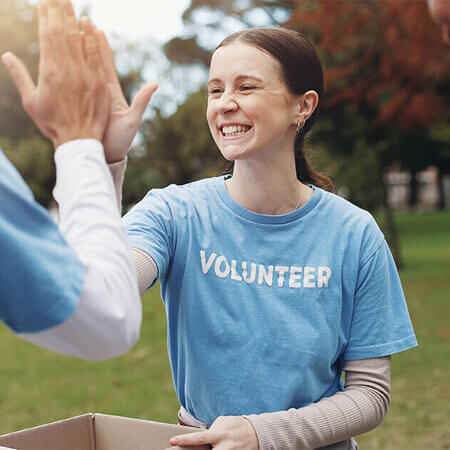 Volunteer workers high fiving