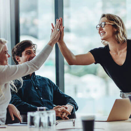 Teammates high fiving at work