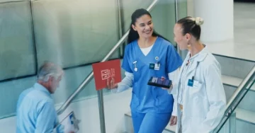 Nurse and doctor walking down stairs in a hospital.