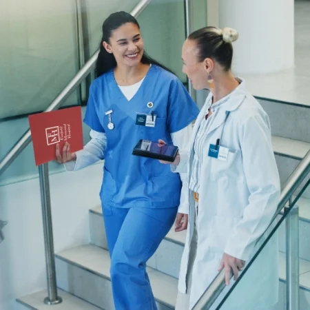 Nurse and doctor walking down stairs in a hospital.