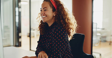 Happy person sitting at their desk at work.