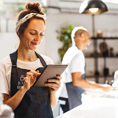 Restaurant owner behind the counter working on a tablet