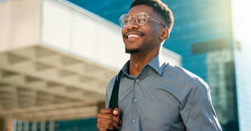 Happy businessman walking outside.