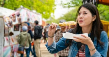 Person eating street food at a carnival.