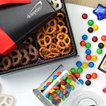 Food and beverage promotional products that include a logoed box of pretzels and candy