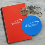 Promotional products made in canada that include a notebook, jar opener, coin and keychains