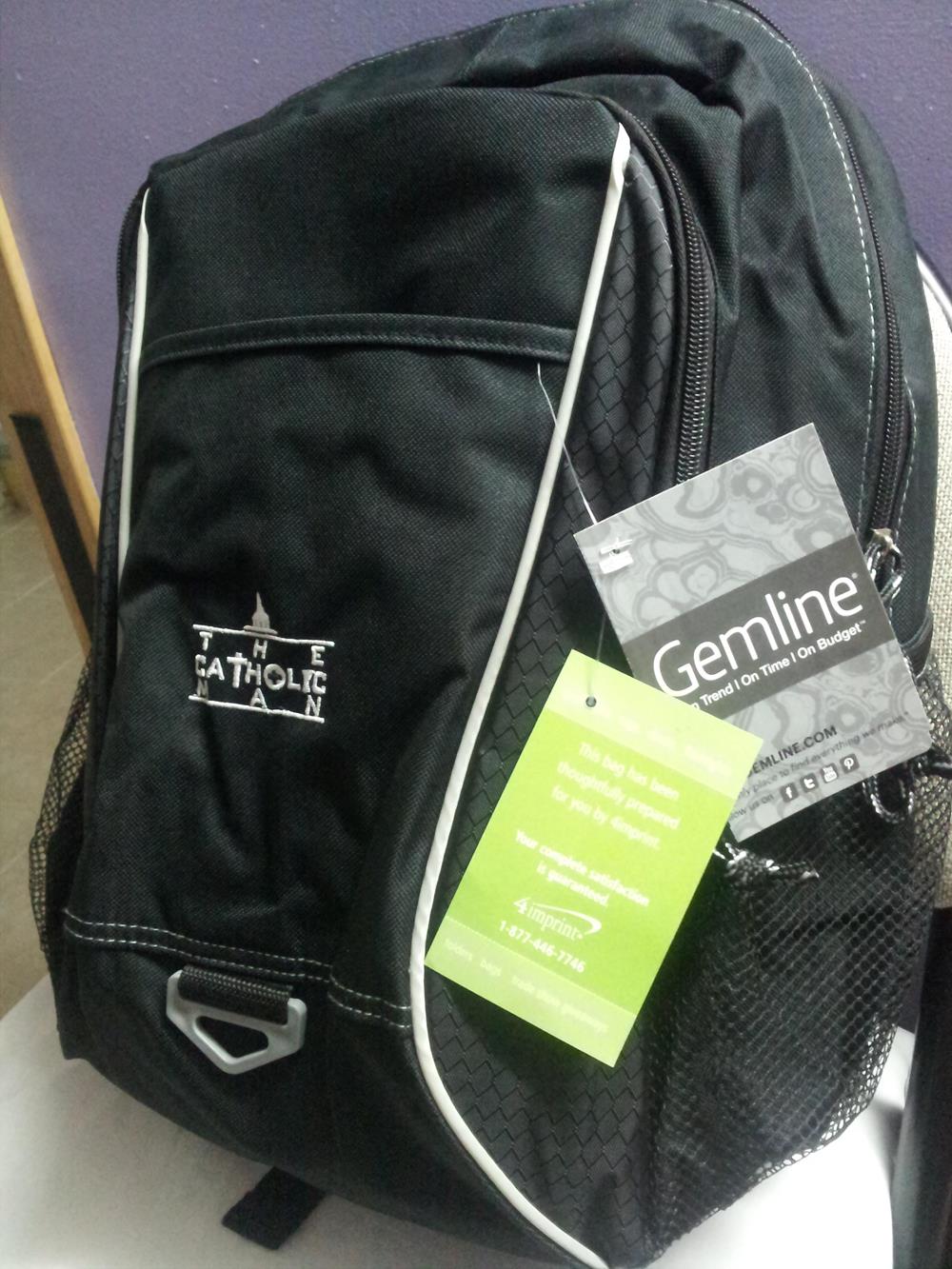 a black backpack with a green tag