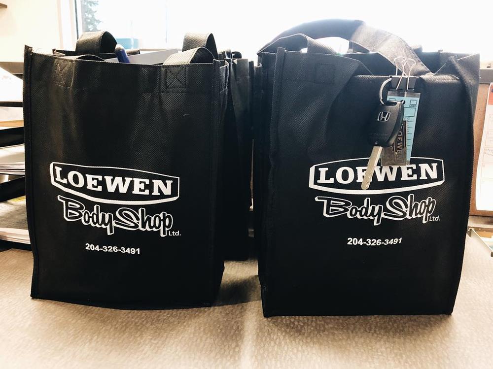 two black bags with white text and a keychain