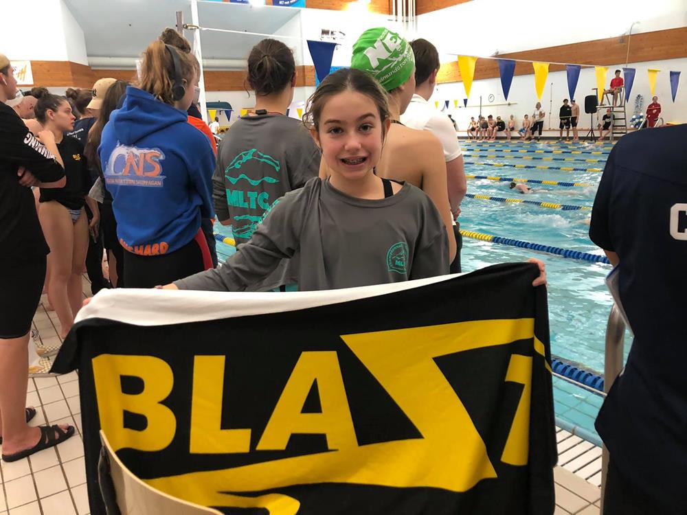 a girl holding a sign in a pool