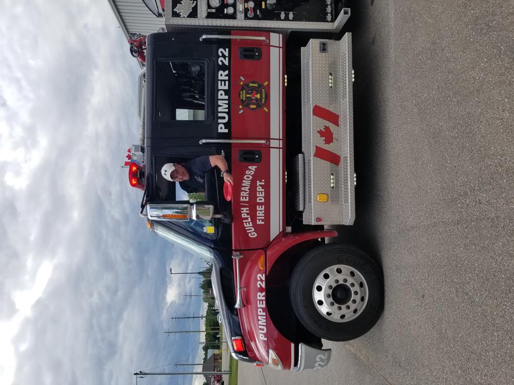 a fire truck with a man standing in the back