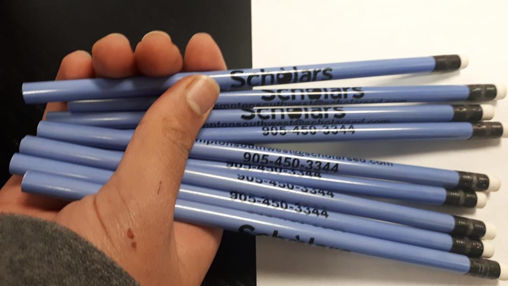 a hand holding several blue pens