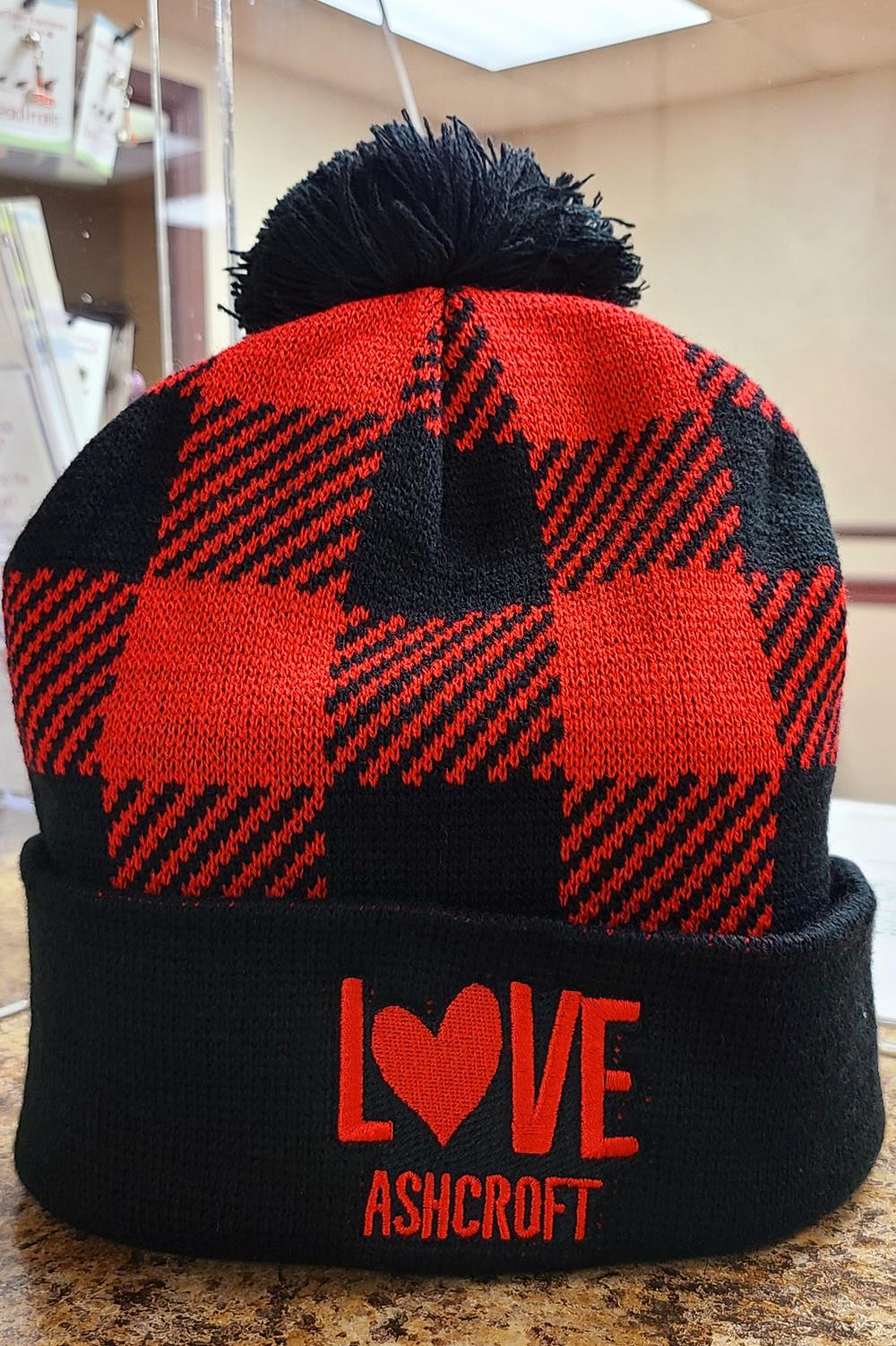 a black and red plaid hat with a pom