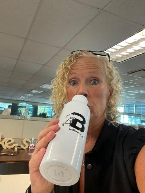 a woman drinking from a white bottle