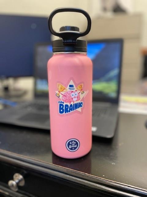 a pink water bottle with a black lid