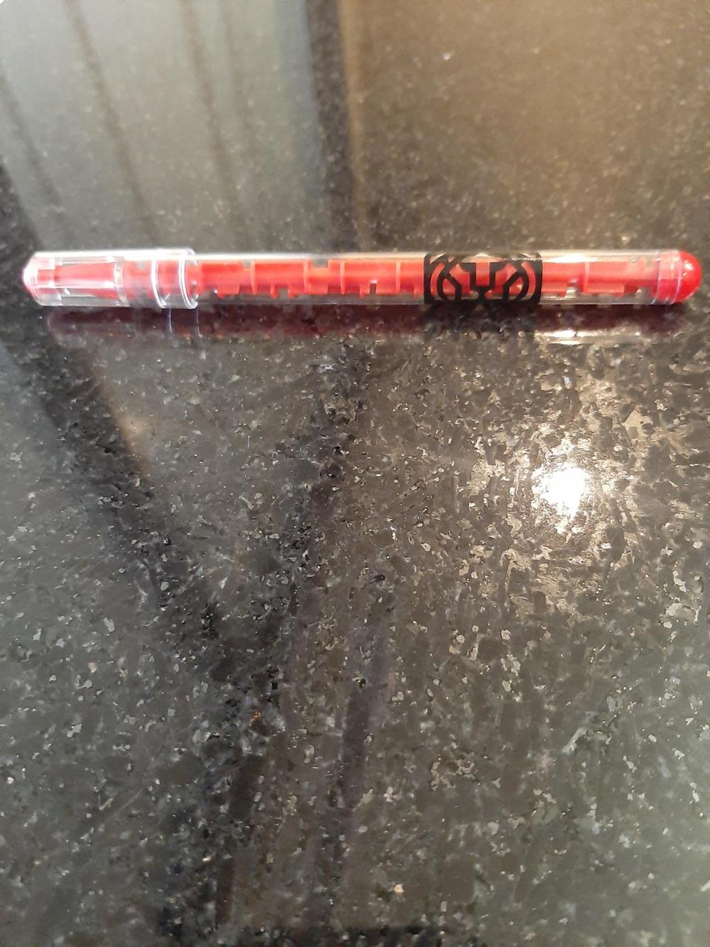 a red pen on a black surface