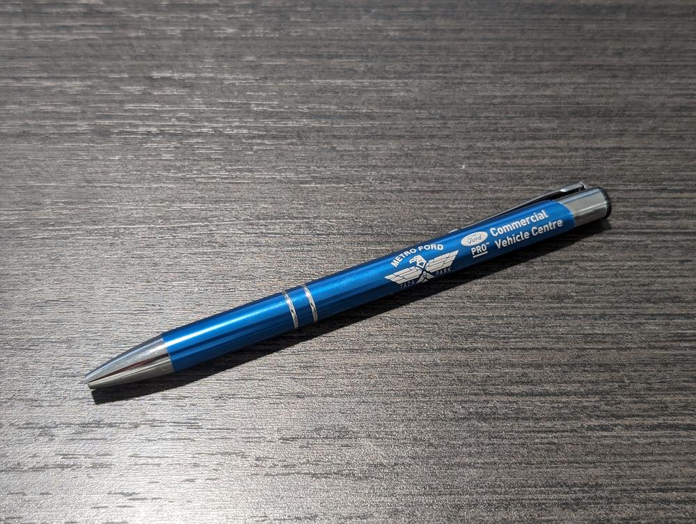 a blue pen on a wood surface