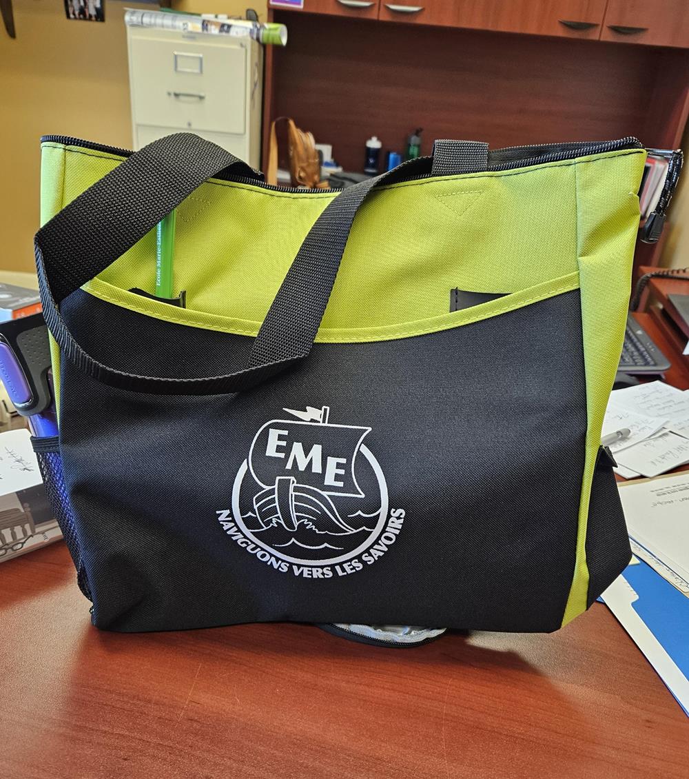 a green and black bag on a desk