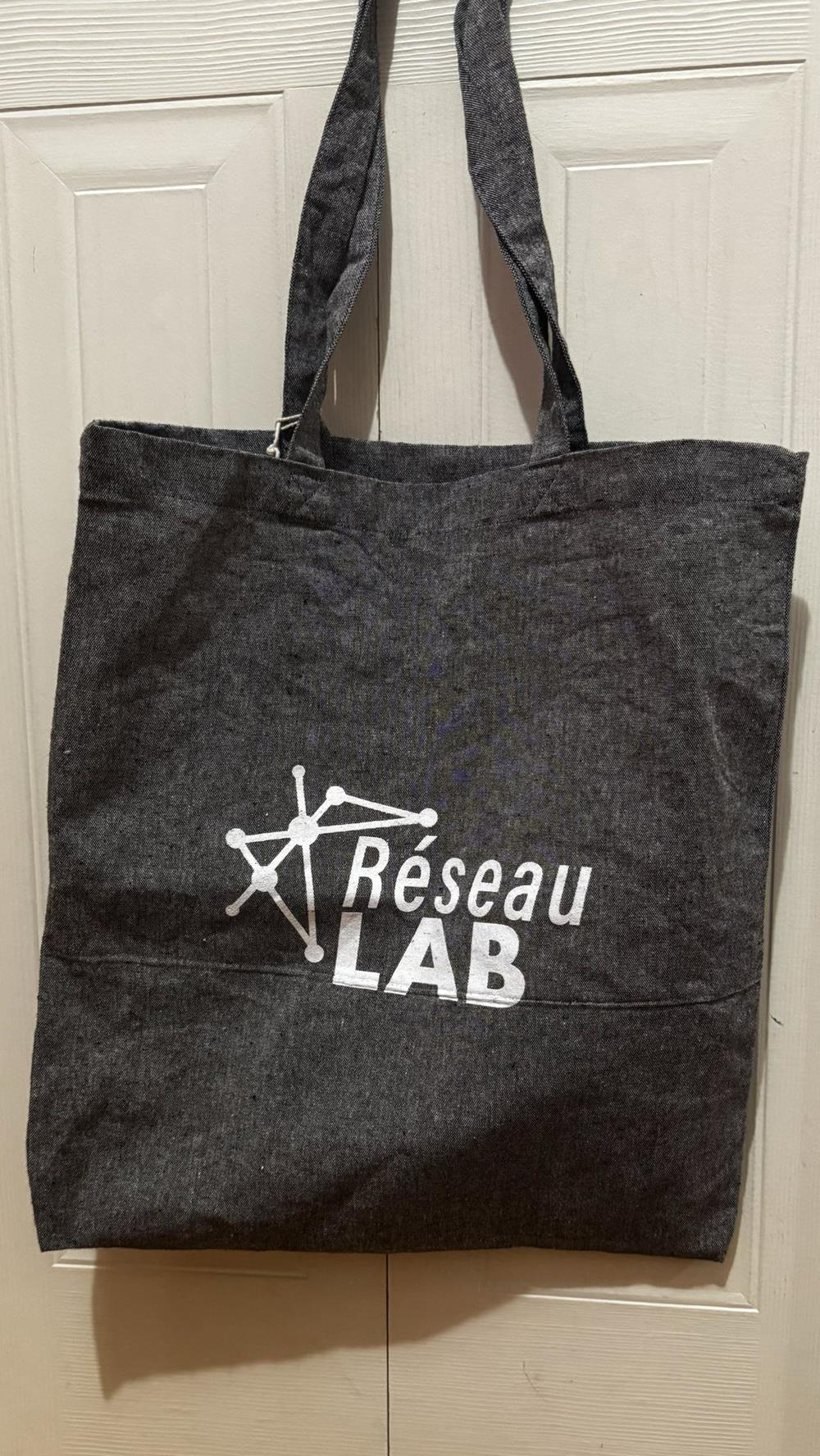 a grey tote bag with white text on it