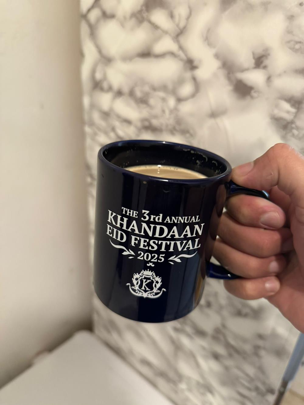 Customer photo from HASAN of our Value Coffee Mug - 11 oz. - Colours, a hand holding a coffee mug