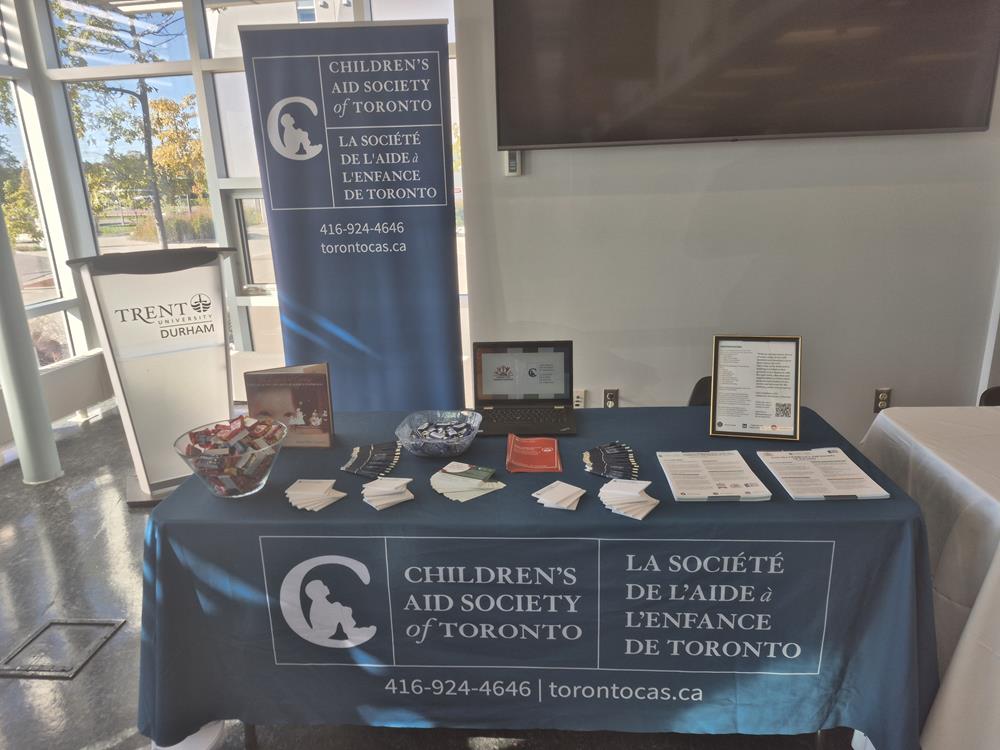 Customer photo from Krupa of our Value Non-Woven Tote, a table with a blue tablecloth and a sign