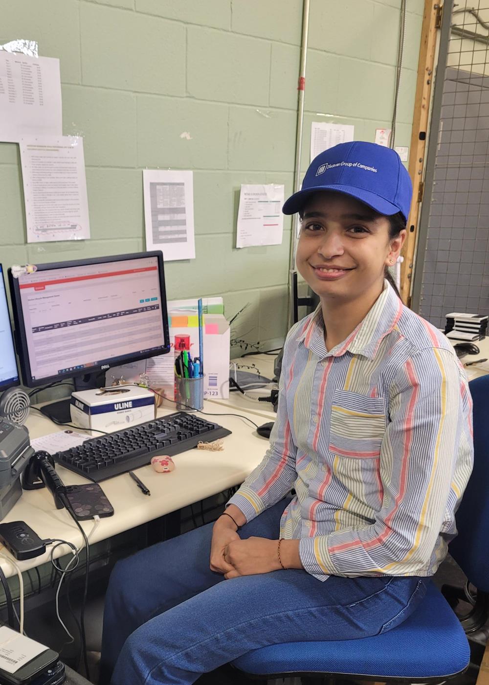 Customer photo from Alex of our Patras Cotton Twill Cap, a woman sitting at a desk with a computer
