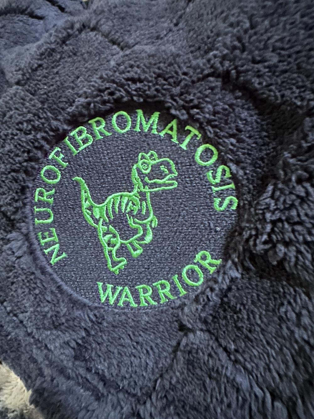 Customer photo from Sue of our Ultra Plush Checkered Pattern Blanket, a black furry object with green text