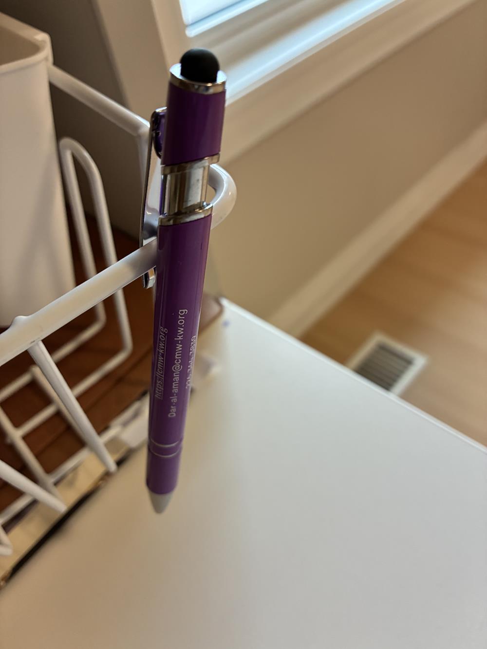 Customer photo from Taghrid of our Shuffle Key Light Tape Measure, a pen on a white holder