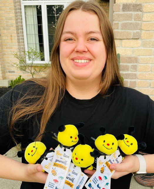 Customer photo from Tracy of our Sidekick Shorty - Bumblebee, a woman holding a group of stuffed animals