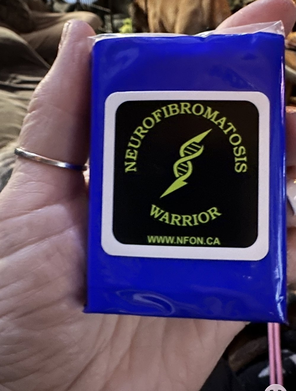 Customer photo from Sue of our Small Tissue Packet, a hand holding a blue package with a yellow and black logo