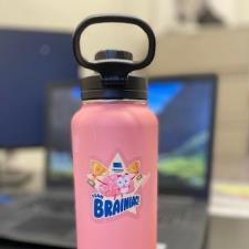 a pink water bottle with a black lid