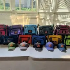 Customer photo from Denise of our 12-Can Convertible Duffel Cooler - Full Colour, a group of bags and hats on a table