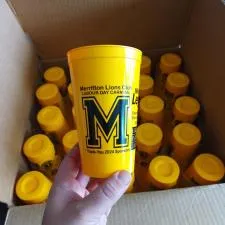 Customer photo from Douglas of our Value Stadium Cup - 20 oz., a hand holding a yellow cup in a box of yellow containers