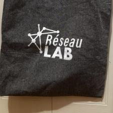 a grey tote bag with white text on it