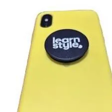 Customer photo from Alison of our Swappable PopSockets PopGrip, a yellow cell phone with a black circle on the side