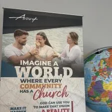 Customer photo from Leah of our Merlin Adjustable Retractable Banner Display, a poster next to a globe