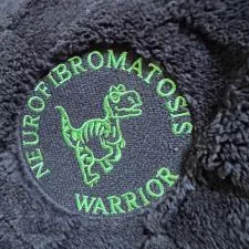 Customer photo from Sue of our Ultra Plush Checkered Pattern Blanket, a black furry object with green text