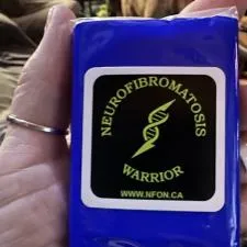 Customer photo from Sue of our Small Tissue Packet, a hand holding a blue package with a yellow and black logo